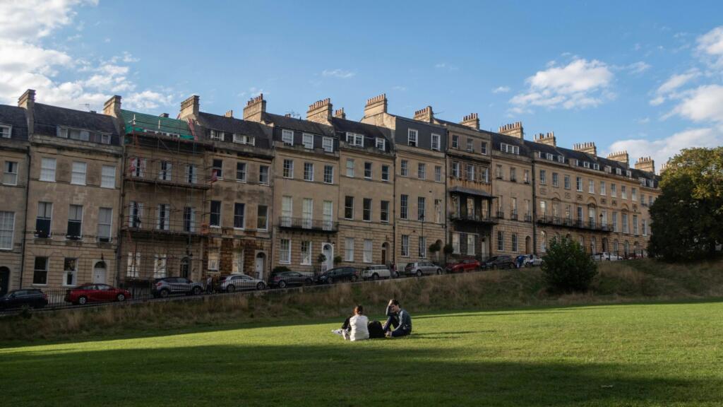 People relaxing on the lawn in front of the Royal Crescent in Bath